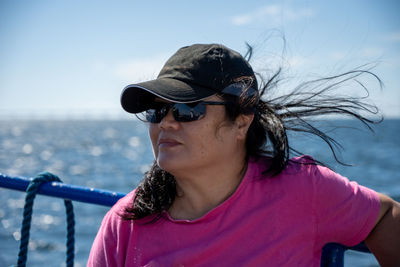 A middle-aged asian woman on a boat trip a hot summer day.