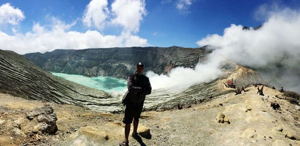 Panoramic view of man standing on mountain against sky