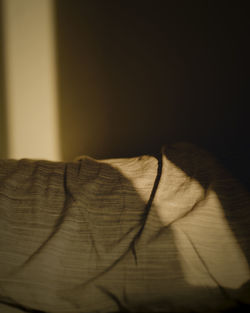 Close-up of shadow on bed at home