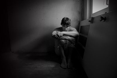 Full length of man sitting in corridor