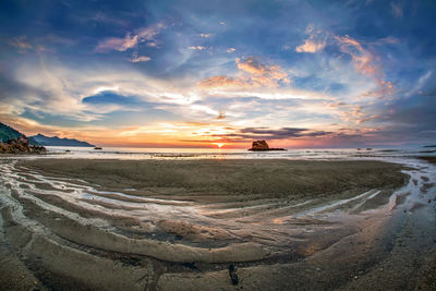 Scenic view of beach against sky during sunset