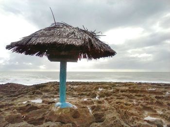 Scenic view of sunshade against cloudy sky