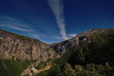 Scenic view of rocky mountains against blue sky