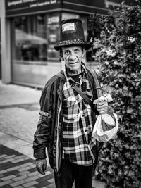 Portrait of chimney sweep wearing hat standing outdoors