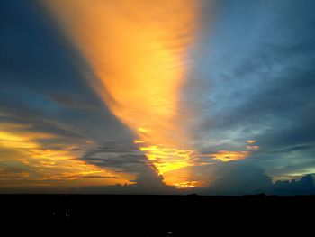 Silhouette of trees against dramatic sky