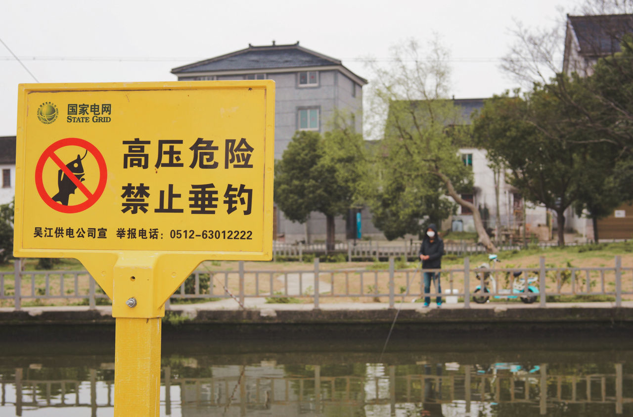 INFORMATION SIGN BY BUILDINGS AGAINST CITY