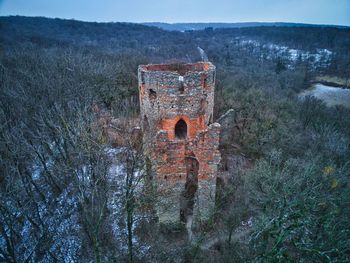 Old abandoned building on field against sky