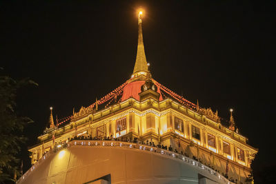 Low angle view of illuminated building against sky at night