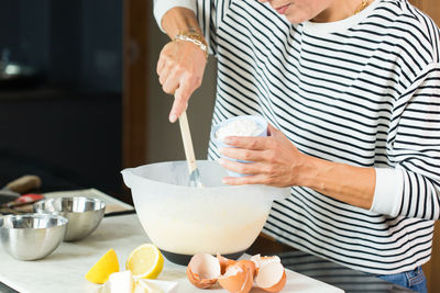 Woman kneading the dough while cooking apple pie in the modern kitchen
