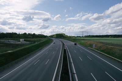 Road passing through landscape against sky