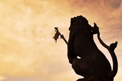 Silhouette of man riding motorcycle on mountain against sky