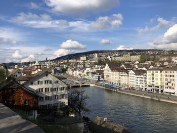 High angle view of river amidst buildings in city against sky