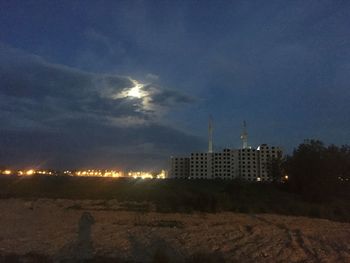 Illuminated city against sky at night