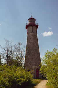 Low angle view of lighthouse amidst buildings against sky