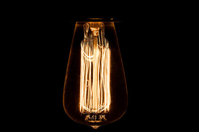 Close-up of illuminated light bulb in darkroom