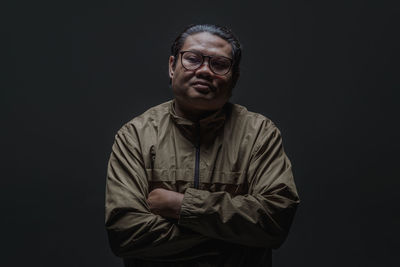 Portrait of man wearing mask against black background