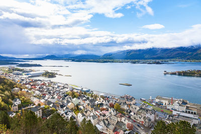 High angle view of city by sea against sky