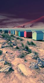 Multi colored chairs on beach against sky during sunset