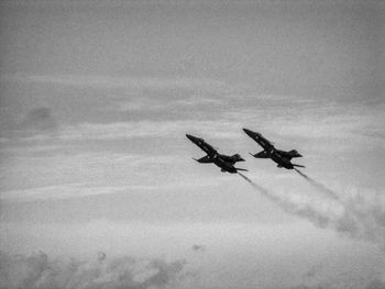 Low angle view of silhouette airplane flying in sky