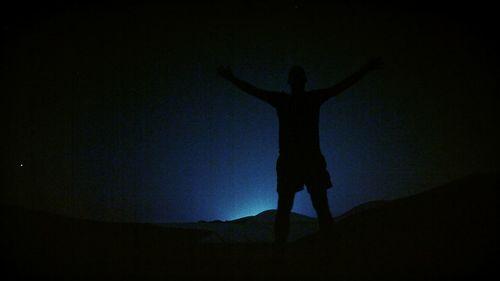 Silhouette man standing against sky at night