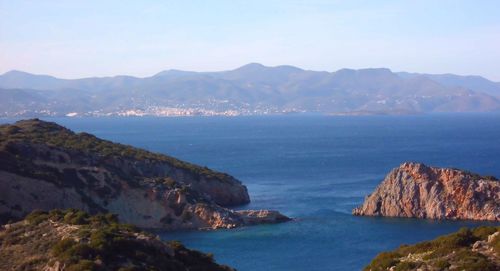 Scenic view of sea and mountains against sky