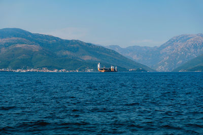 Scenic view of sea and mountains against sky