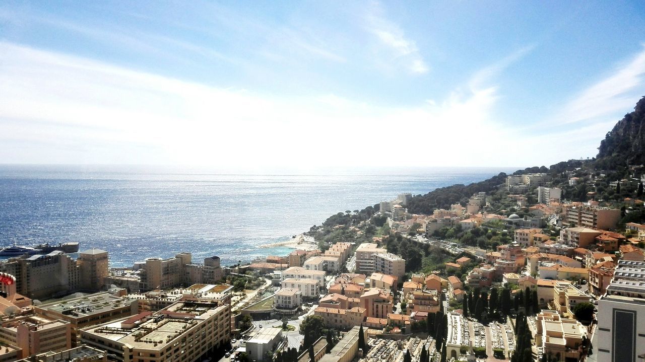 sea, building exterior, architecture, built structure, horizon over water, high angle view, sky, cityscape, water, crowded, residential district, city, residential structure, residential building, town, townscape, cloud - sky, aerial view, blue, house