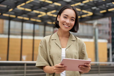 Portrait of young woman using mobile phone