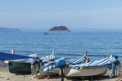 The small beach of laigueglia with small fishing boats and an island in the background