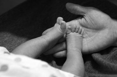 Cropped hand touching feet of baby