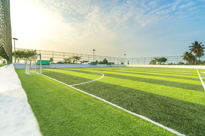 Soccer field against sky during sunset