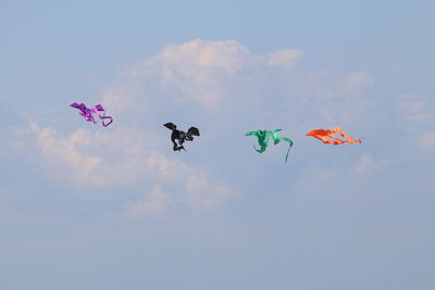 Low angle view of kites flying in sky