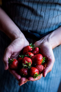 Midsection of person holding strawberries