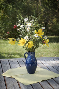 Close-up of yellow flower pot on table