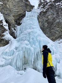 Rear view of man on snow covered mountain