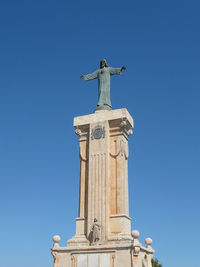 Low angle view of statue against clear blue sky