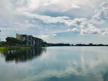 Scenic view of lake by buildings against sky