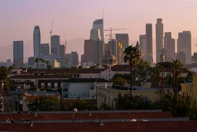 Modern cityscape against sky during sunset