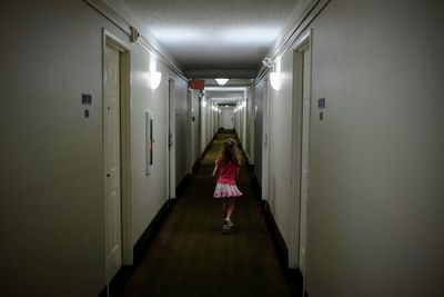Rear view of woman standing in illuminated building