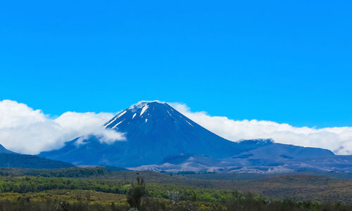 Scenic view of snowcapped mountains against blue sky