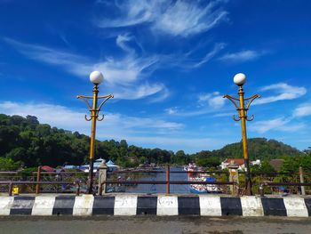 Street light by road against blue sky