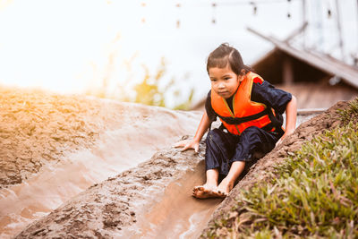 Full length of girl sliding on slope