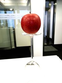 Close-up of apple on glass table