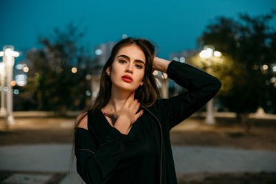 Portrait of beautiful young woman at night