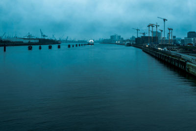Pier over sea against sky in city