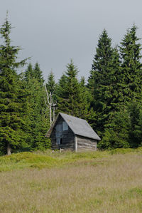 Built structure on field against trees in forest