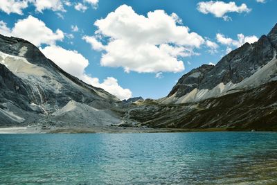 Scenic view of lake by mountains against sky