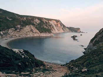 Scenic view of sea and mountains against sky