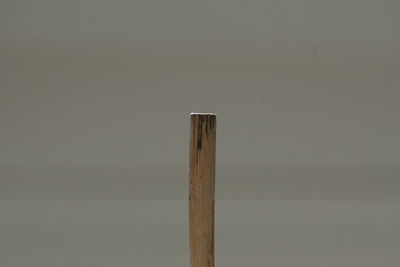 Close-up of wooden post against sky