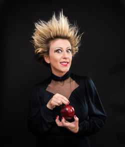 Portrait of young woman against black background